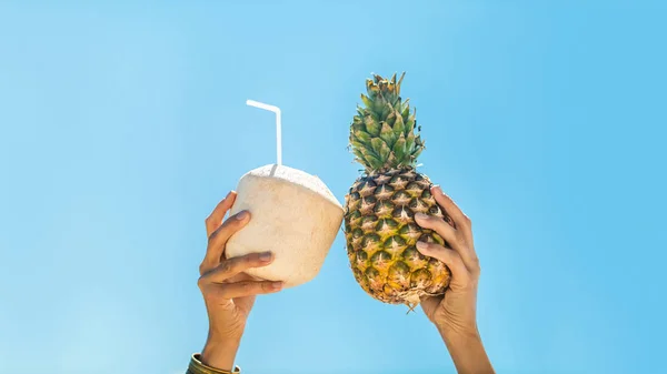 Mãos segurando frutas tropicais sobre fundo céu — Fotografia de Stock