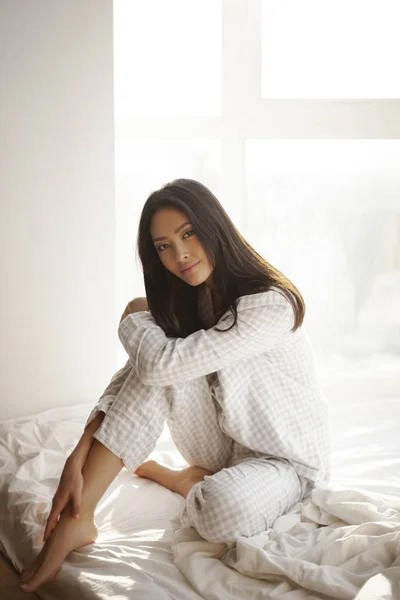 Mujer asiática sentada en la cama en casa — Foto de Stock