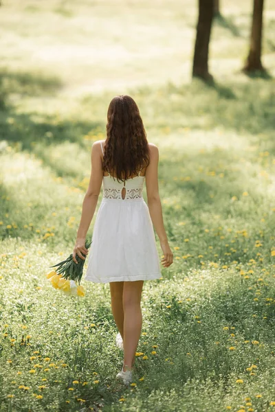 Kvinna med bukett av våren blommor utomhus — Stockfoto