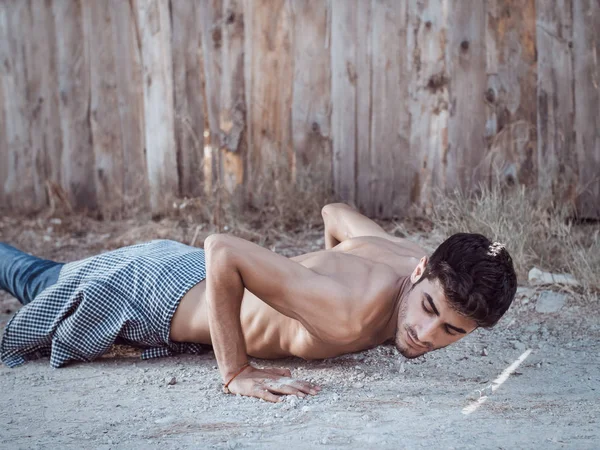 Photo d'un jeune homme athlétique faisant des pompes à l'extérieur . — Photo