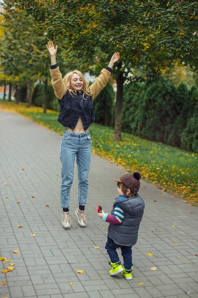 Mãe feliz brincando com seu filho no parque — Fotografia de Stock