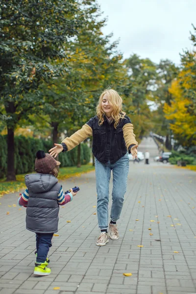 Mãe feliz brincando com seu filho no parque — Fotografia de Stock