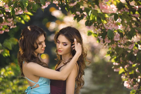 Foto de retrato de moda de dos mujeres cerca del árbol en flor en la naturaleza — Foto de Stock