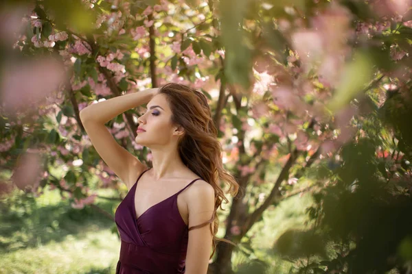 Kvinna vid blommande Sakura träd på naturen — Stockfoto