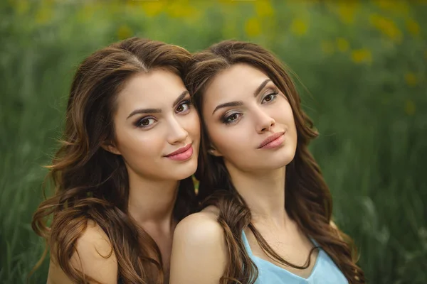 Foto de retrato de moda de dos mujeres contra prado de hierba verde en la naturaleza — Foto de Stock