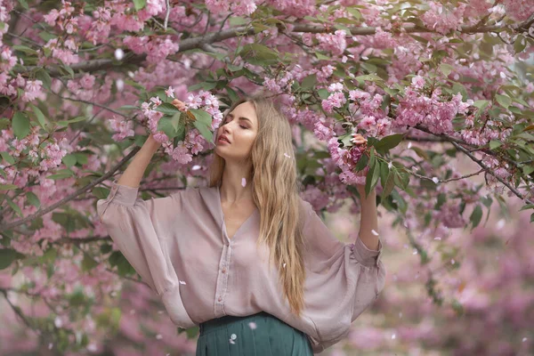 自然の中で桜の木を開花させる女性 — ストック写真