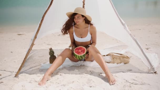 トロピカルビーチでスイカを食べる女性 — ストック動画