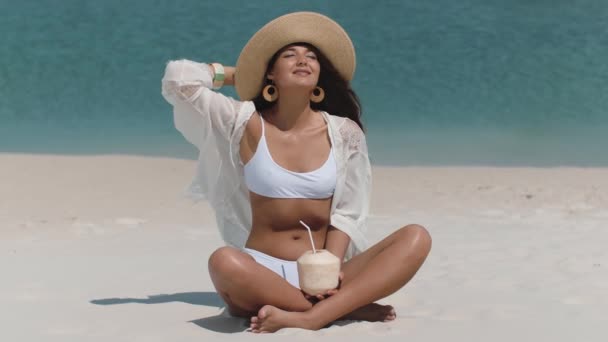 Opalona kobieta w bikini z kokosem na plaży — Wideo stockowe