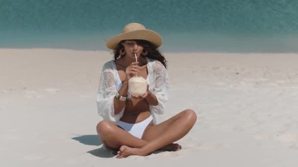 Mujer bronceada en bikini con coco en la playa — Vídeos de Stock