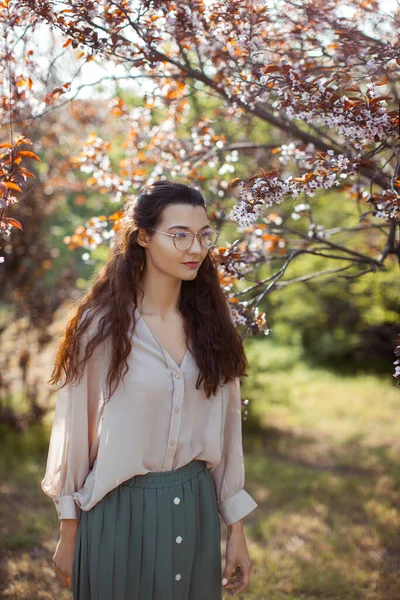 Donna all'aperto nel parco vicino all'albero dei fiori di primavera — Foto Stock