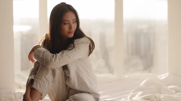 亚洲妇女坐在家里的床上 — 图库视频影像