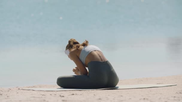 Женщина медитирует в позе йоги на пляже — стоковое видео