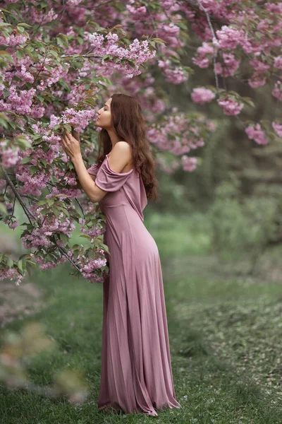 Женщина в цветущей сакуре на природе — стоковое фото