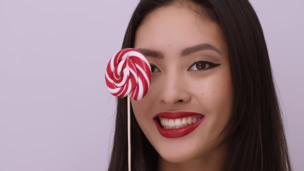 演播室里带棒棒糖的亚洲女人的时尚肖像 — 图库视频影像