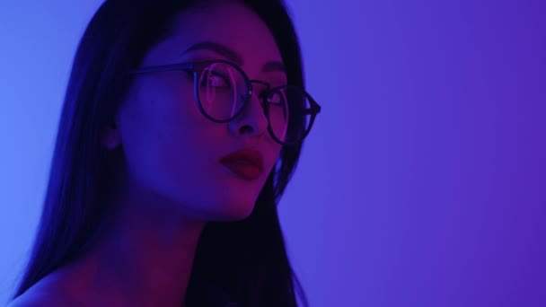 Studio Porträtt av asiatisk kvinna med neonljus. — Stockvideo