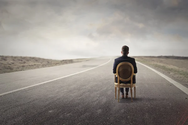 Man in a chair on the road — Stock Photo, Image