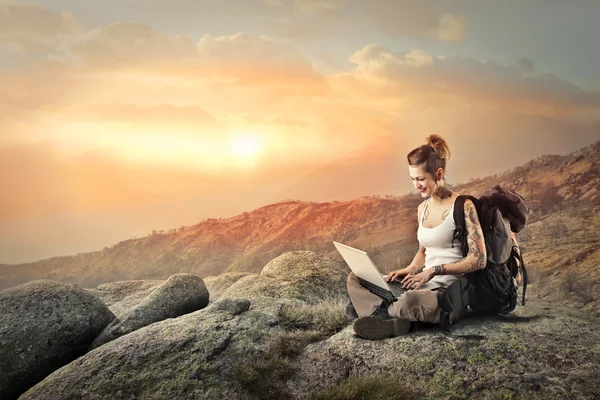Vrouw is met behulp van haar laptop in de natuur — Stockfoto
