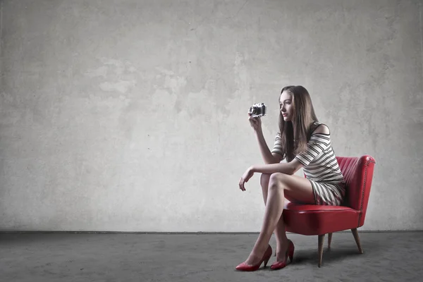 Femme avec une caméra dans un fauteuil — Photo