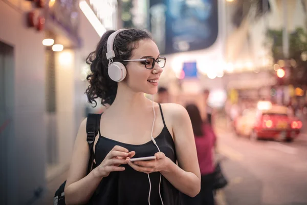 Mujer en la ciudad en auriculares — Foto de Stock