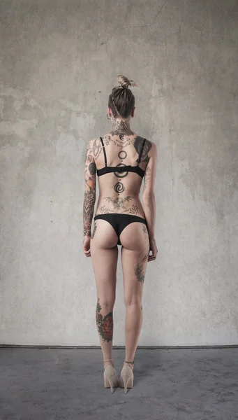 Татуированная женщина сзади — стоковое фото