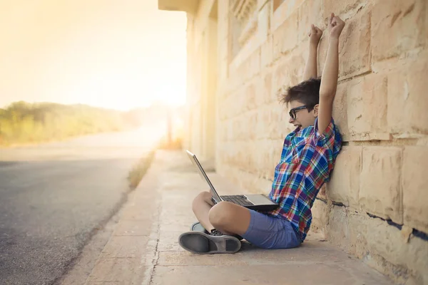 Niño con un ordenador portátil — Foto de Stock