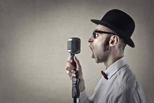Hombre gritando en un micrófono — Foto de Stock
