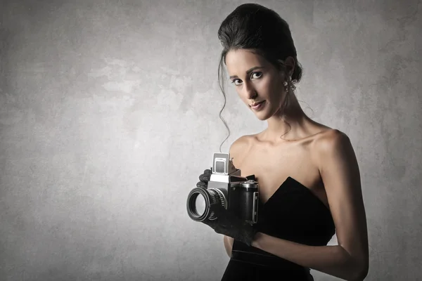 Woman in black dress with a photo machine — Stock Photo, Image