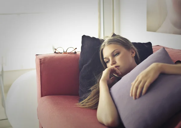 Woman is laying on a coach — Stock Photo, Image