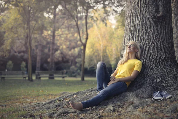 Meisje rusten in de bodem van een boom — Stockfoto