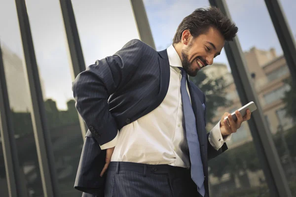 Homem de negócios está usando seu telefone — Fotografia de Stock