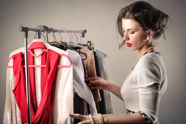 Estilista olhando para suas roupas — Fotografia de Stock