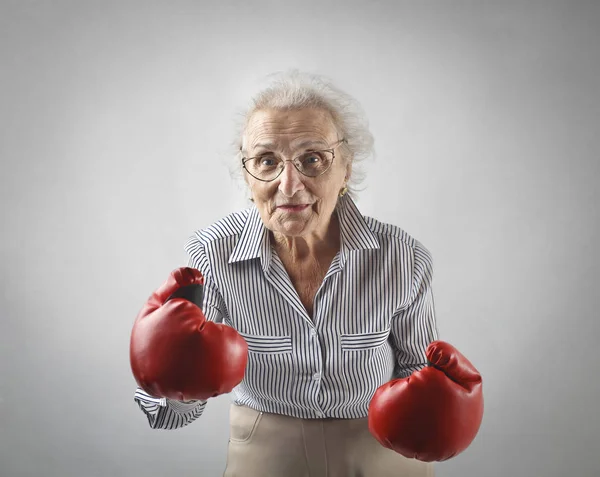 Oude dame met bokshandschoenen — Stockfoto