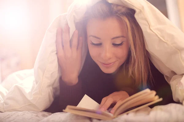 Lezende vrouw in bed — Stockfoto