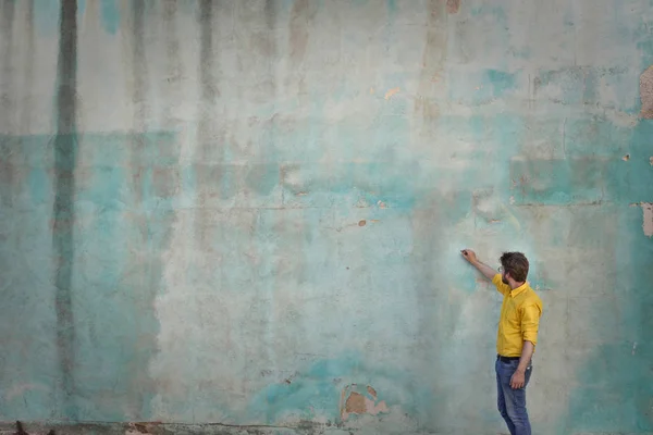 Человек рисует на пустой стене — стоковое фото