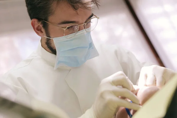 Стоматолог в окулярах працює — стокове фото