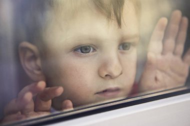 Çocuk pencereden dışarı bakıyor
