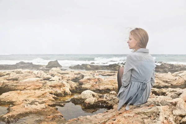 Žena sedí na pláži — Stock fotografie