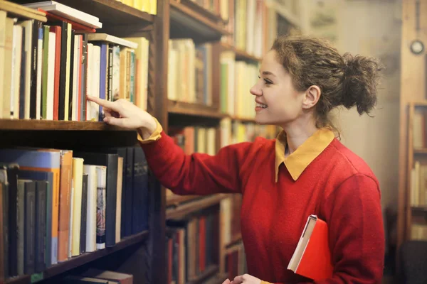 Frau sucht ein Buch — Stockfoto