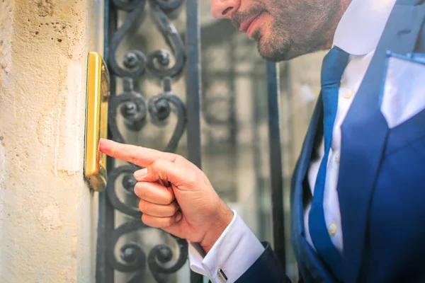 Empresário empurrando campainha da porta — Fotografia de Stock