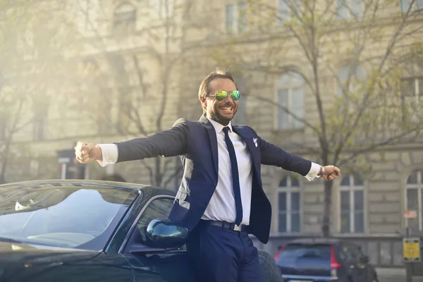 Businessman leaning on car — Stock Photo, Image