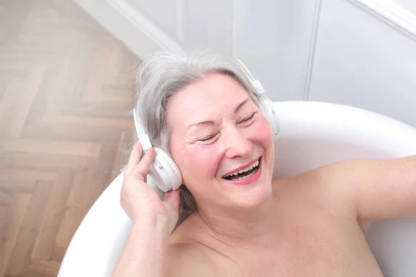 Senhora mais velha ouvindo música — Fotografia de Stock
