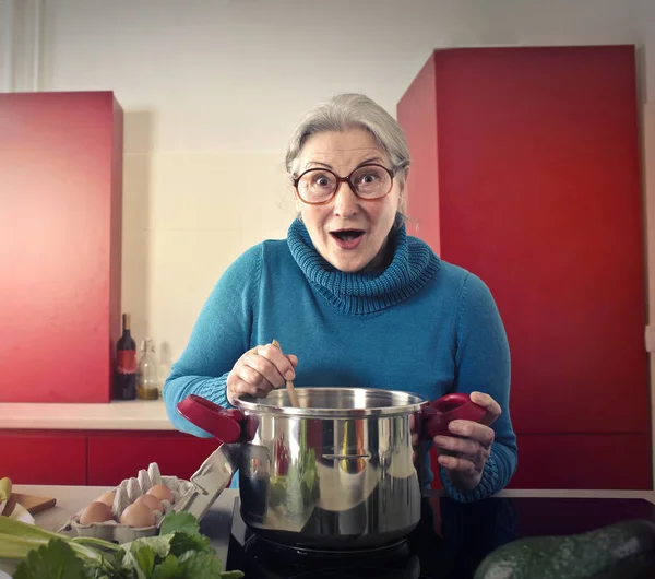 Senhora cozinhar e fazer cara boba — Fotografia de Stock