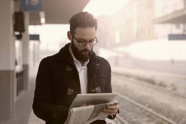 Empresário lendo na estação de trem — Fotografia de Stock