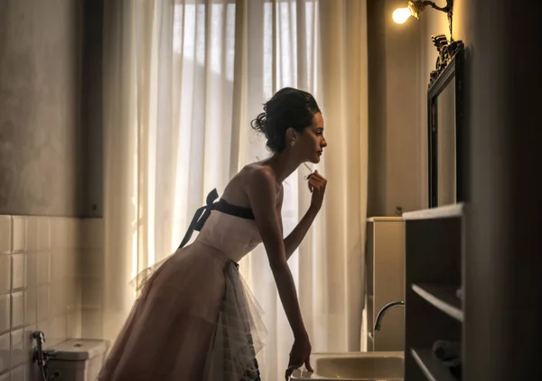 Elegante vrouw op zoek naar spiegel — Stockfoto