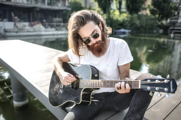 Hipster man spela på gitarr — Stockfoto