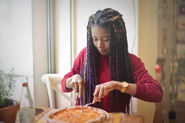 Черная девушка ест пиццу — стоковое фото