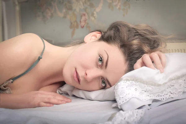 Mavi gözlü kadın yatakta — Stok fotoğraf