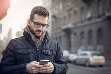 Şehirde akıllı telefonu olan genç bir adam.