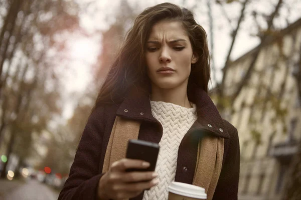 Mujer confundida sobre su teléfono —  Fotos de Stock