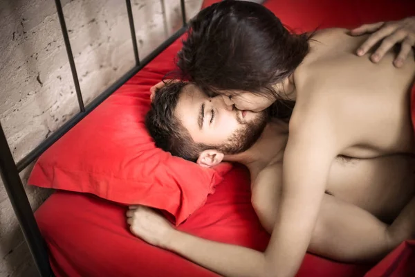 Casal beijando e deitado na cama — Fotografia de Stock